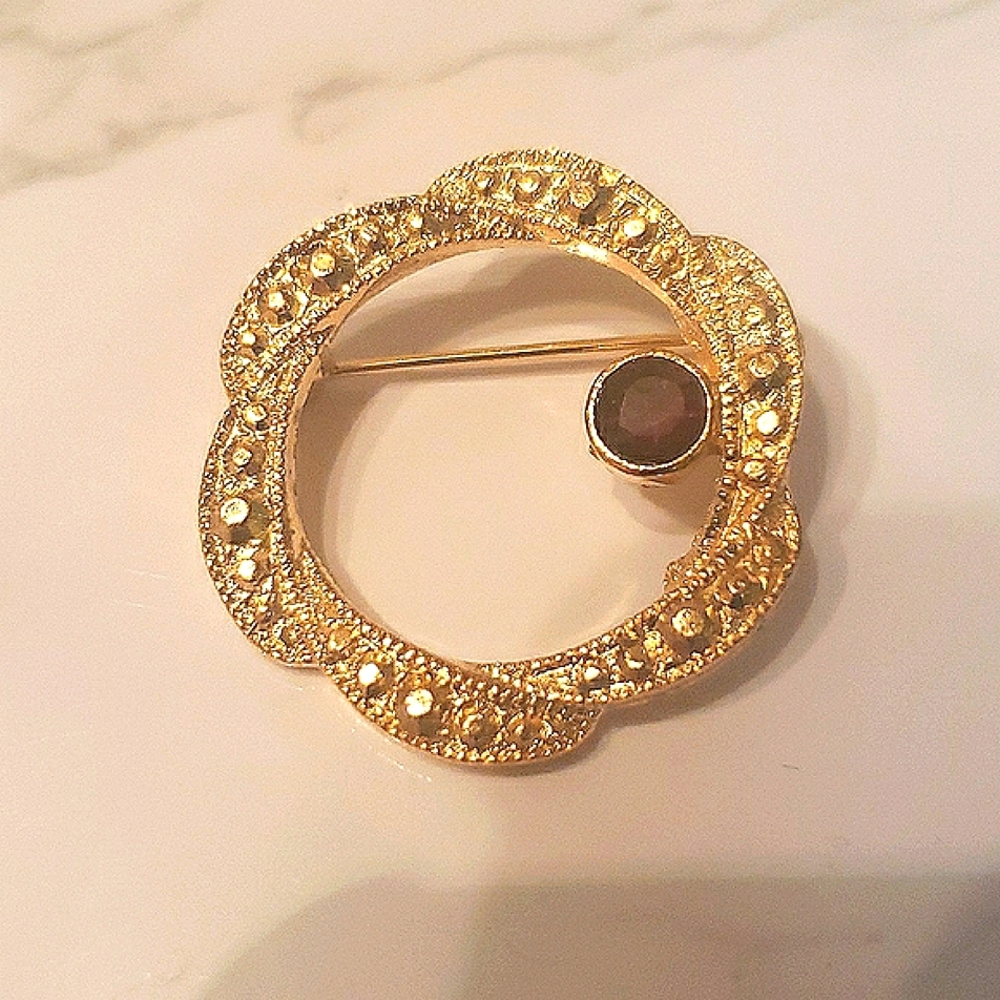 Vintage goldtone circle pin with garnet colored stone